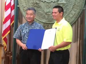 Governor David Ige signs a proclamation announcing August as Pedestrian Safety Month with Ed Sniffen, Highways Division Deputy Director. 