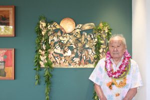 Artist and sculptor Satoru Abe, 90, stands beside his work “Sunburst” located at the Honolulu International Airport.
