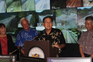 HDOT Director Ford Fuchigami (at the podium), along with State Senator Michelle Kidani (left), Honolulu Mayor Kirk Caldwell and Governor David Ige, announce the annual “Beat the School Jam” campaign to encourage the public to plan ahead and inform motorists of the latest traffic relief improvements projects.