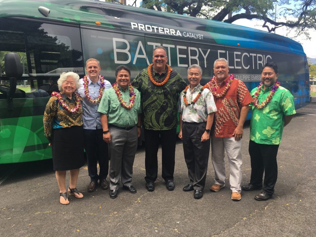 Kauai Mayor Bernard Carvalho; Hawaii State Energy Office Administrator Carilyn Shon; Governor David Y. Ige; BYD Vice President Bobby Hill; HDOT Director Jade Butay; Hawaiian Electric General Manager Brennon Morioka; and City & County of Honolulu Department of Transportation Services Deputy Director Jon Nouchi stand in front of the BYD bus.