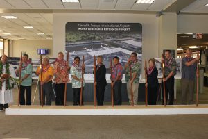 Kahu Kordell Kekoa (from left to right), HDOT Airport Division Deputy Director Ross Higashi, Rep. Richard Onishi, Airlines Committee of Hawaii Co-Chair Blaine Miyasato, House Vice Speaker Mark Nakashima, Governor David Ige, HDOT Director Jade Butay, Senate President Ronald Kouchi, Sen. Lorraine Inouye, Hawaiian Airlines President &amp; CEO Peter Ingram, Hensel Phelps Vice President Thomas Diersbock participate in the turning of the soil with O'o sticks.