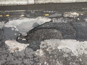 Before photo of a pothole in the Zipper Lane.