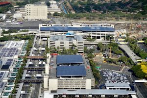 Aerial view showing the Terminal 2 garage solar panels at HNL in the foreground.