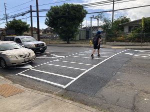 A pedestrian uses one of the five raised crosswalks on Kalihi Street that were installed in May 2019. Photo courtesy HDOT or Hawaii Department of Transportation.